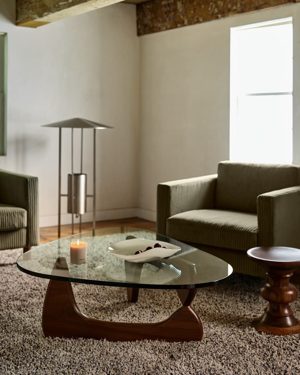 Herman Miller Noguchi Table with a freeform glass top on an interlocking walnut base