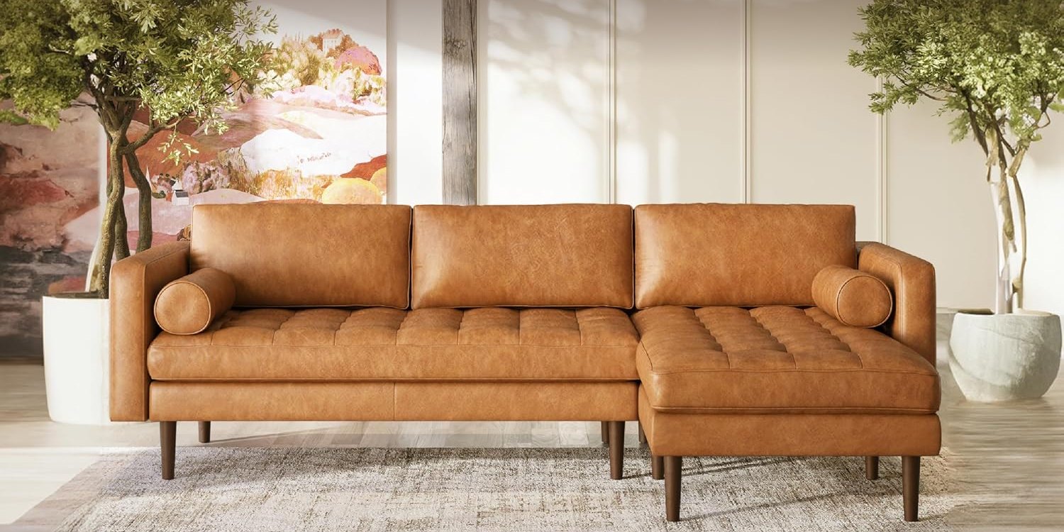Poly & Bark Napa cognac leather chaise sectional in a living room with olive trees and a vintage rug